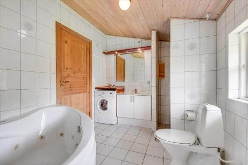 a bathroom with a tub and a toilet and a sink at C11645-Hemmet-Kosigvaenget-100 in Hemmet