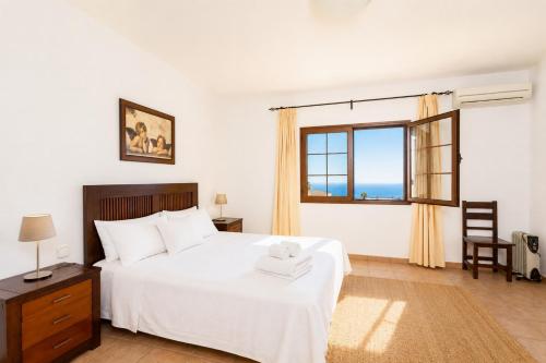 a bedroom with a white bed and a window at Villa El Callao in La Asomada