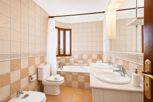 a bathroom with two sinks and a toilet and a tub at Villa El Callao in La Asomada