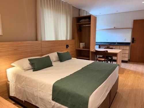 a bedroom with a large bed and a table at POUSADA MILÊNIO LTDA in Ponte Nova