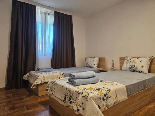 a bedroom with two beds and a window at Къща за гости Калабрия in Golden Sands