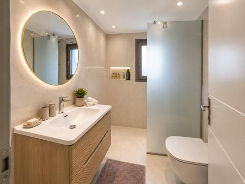 a bathroom with a sink and a toilet and a mirror at City Calm House in Platánion