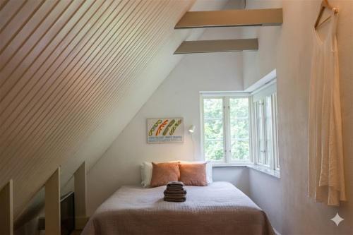 a room with a bed in a attic with a window at Gladeholm in Kivik