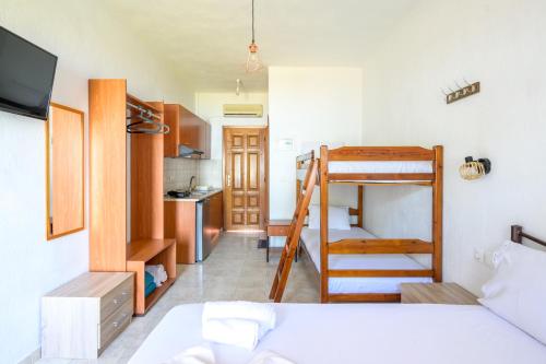 a bedroom with a bunk bed and a kitchen at Studios Efi beach in Vourvourou
