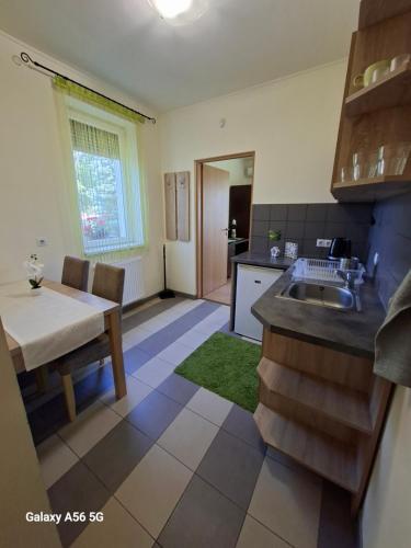 a kitchen with a table and a sink and a table and a dining room at Tölgyfa Vendégház in Kiskőrös