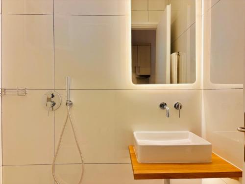 a white bathroom with a sink and a shower at Vaya Zorba Studios in Skiathos