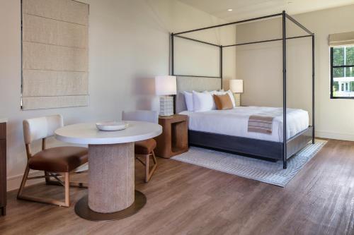 a hotel room with a bed and a table and chair at Duchamp Healdsburg in Healdsburg