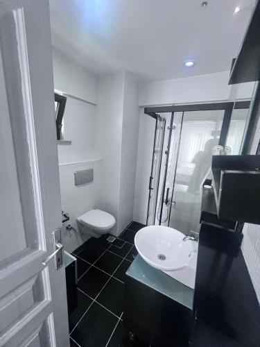 a bathroom with a white toilet and a sink at Dardanos Pension in Hamidiye
