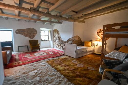 a living room with a couch and a bed at Quinta Da Carvalheira Regenerative Coliving in Soure