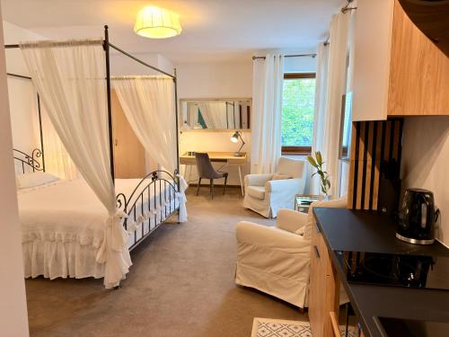 a bedroom with a canopy bed and a living room at Villa Gdynia in Gdynia
