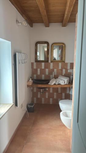 a bathroom with two sinks and two mirrors at Fattoria solidale del Circeo in Pontinia
