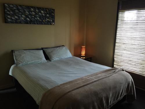 1 dormitorio con 1 cama y ventana con lámpara en 15 on Blair, en Peterborough
