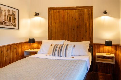 a bedroom with a bed with two night stands and two lamps at Portaria Heritage House in Portaria