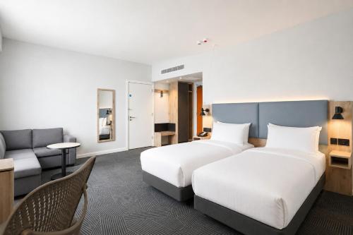 a hotel room with two beds and a couch at Holiday Inn London Luton North in Luton