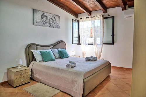 a bedroom with a bed with two stuffed animals on it at Villa Mendolia in Villaggio Mosè