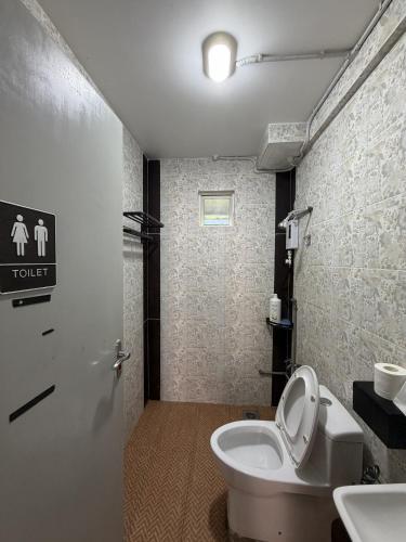 a bathroom with a toilet and a sink at 5 Minutes Away Airport Lodge in Putatan