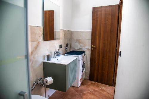 a bathroom with a sink and a washing machine at Villa Mendolia in Villaggio Mosè
