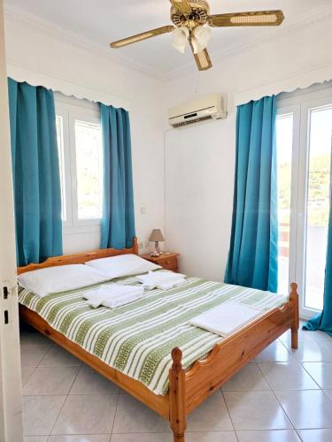 a bedroom with a bed with blue curtains at Emporios Blue Apartment in Emborios