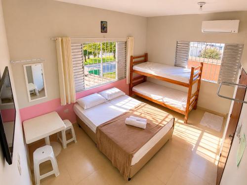 a bedroom with two beds and a bunk bed at Pousada Pura Vida Bertioga in Bertioga