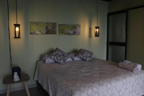 a bedroom with a bed and two lights on the wall at Itawa ecoparque in Villavicencio