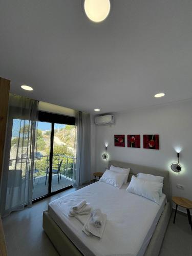 a bedroom with a large white bed with towels on it at Azzurre Premium Aparthotel in Sarandë