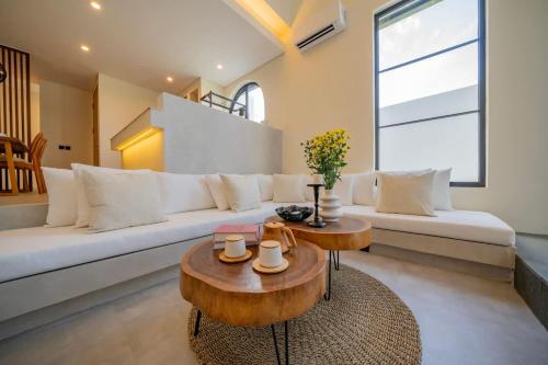 a living room with a white couch and a table at 2BR villa w - pool & beach access in Mengwi