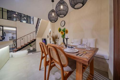 a dining room with a wooden table and chairs at 2BR villa w - pool & beach access in Mengwi