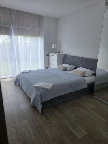 a bedroom with a large bed and a large window at 3 rooms 2 beds 1 sofa-bed apartment with garden in Kaunas