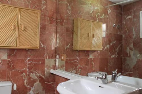 a bathroom with a sink and wooden cabinets at New listing! House with pool and garden, Urús in Urus
