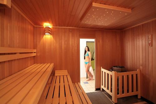 a woman is standing in a sauna at Best Western Plus Hotel Am Schlossberg in Nürtingen