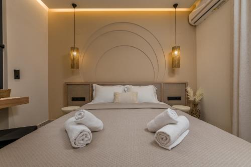 a bedroom with a bed with towels on it at Six Doors in Pefkochori