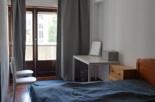 a bedroom with a desk and a bed and a window at apartamento 2000 in Algés