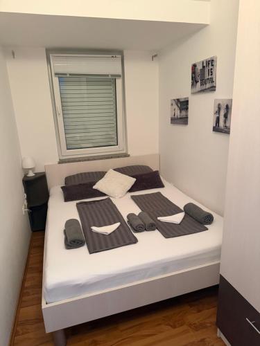 a bedroom with a white bed with a window at Apartments-LUCKY STAR,NOVALJA -PAG in Novalja