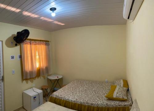 a small bedroom with a bed and a window at Hospedaria genivaldo in Santo Amaro