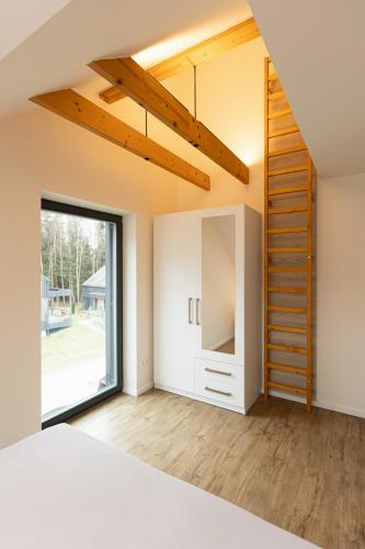 a room with a bed and a staircase and a window at Lipno Verde in Lipno nad Vltavou