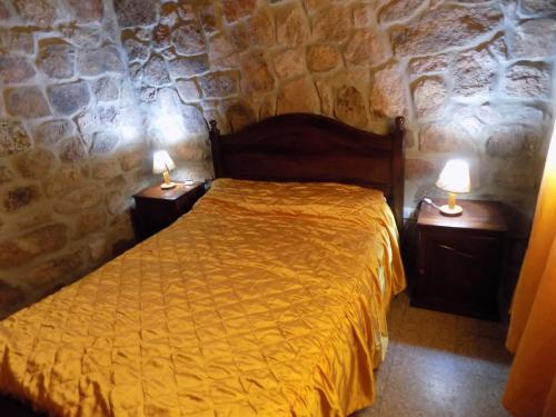 a bedroom with a bed and two lamps on night stands at Cabañas Wasirumi Pileta y bajada al Rio in Bialet Massé