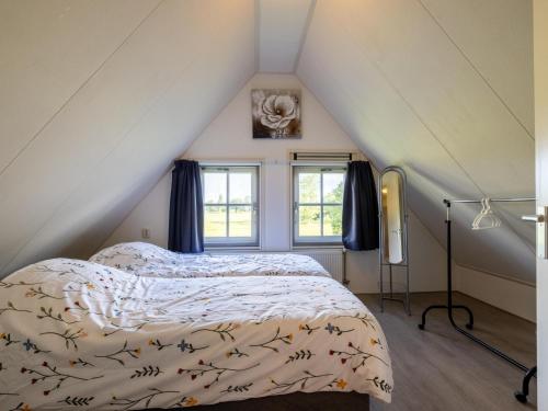 a bedroom with a bed and two windows at Limosa in Hippolytushoef