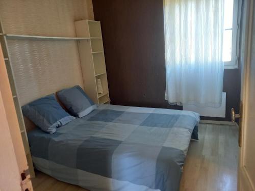 a bedroom with a blue bed with a window at Bellevue in Carbon-Blanc