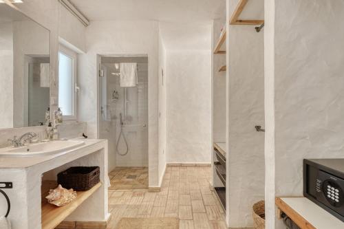 a white bathroom with a sink and a shower at The Pink Stork Villa in Alcácer do Sal