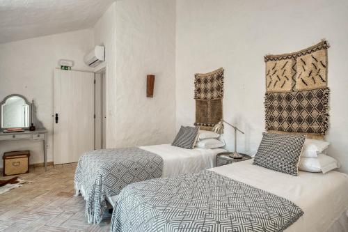 a hotel room with two beds and a mirror at The Pink Stork Villa in Alcácer do Sal