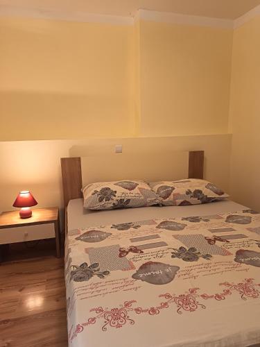 a bedroom with a bed and a table with a lamp at Apartman sa suncem in Beli