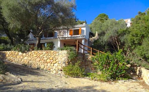 a house on a hill with a stone wall at Villa Liliana P9275 in Torre delle Stelle