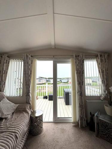 a bedroom with a bed and a view of a deck at Coastal Escape Bude Resort in Bude