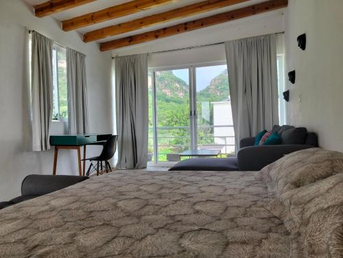 a bedroom with a large bed with a large window at Mi casa de campo Tlayacapan in Tlayacapan