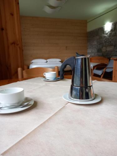 a tea kettle sitting on a table with two cups at Residence Biancaneve in Aprica