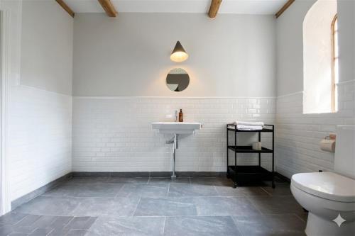 a white bathroom with a sink and a toilet at Gladeholm - Kivik - artist studio in Kivik