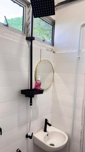 a bathroom with a mirror and a sink at Arkan Motel Transit in Kampung Kuala Besut