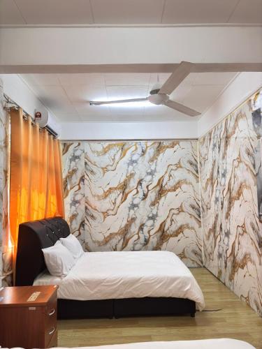 a bedroom with a bed and a wall with a mural at Arkan Motel Transit in Kampung Kuala Besut