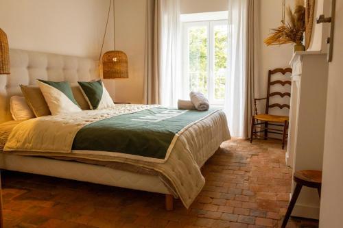 a bedroom with a large bed with a window at Gites Lisael et le 1808 proches Puy DuFou in Mauléon