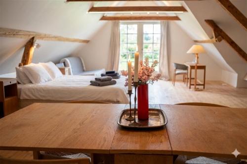 a room with a bed and a table with flowers on it at Gladeholm - Kivik - artist studio in Kivik